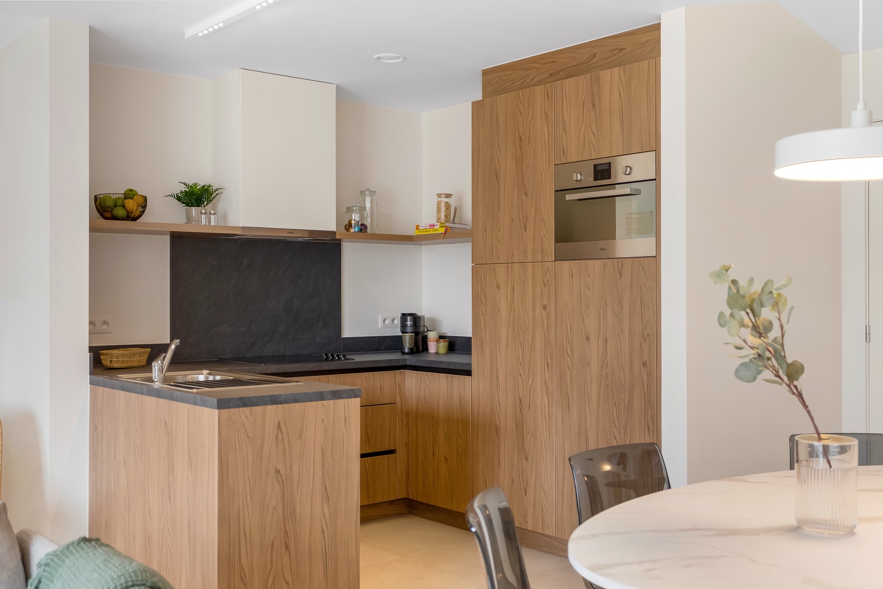 Keuken met maatkasten in houtdecor en donkere werkbladen