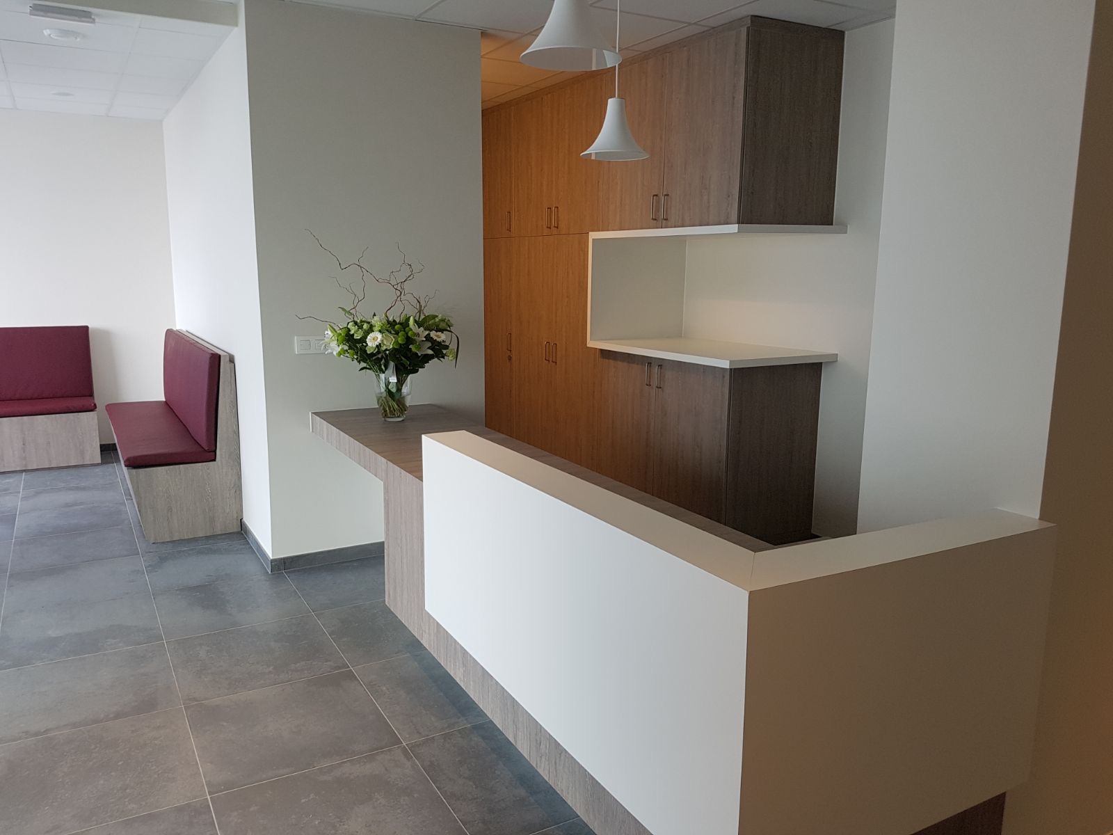 Onthaalmeubel met maatkasten en zitbanken in zorgomgeving